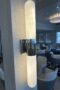 Cylinder sconce with metal mount in center, long curved ends