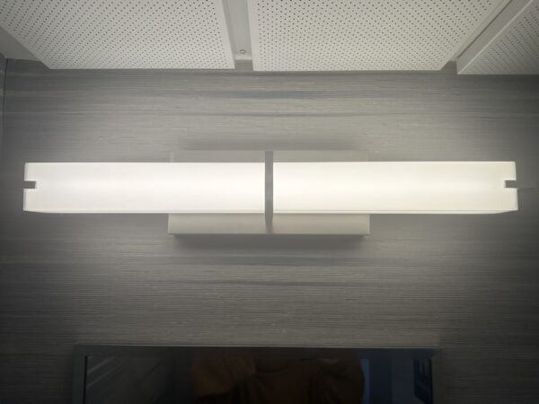 Long bar style mounted sconce above bathroom mirror