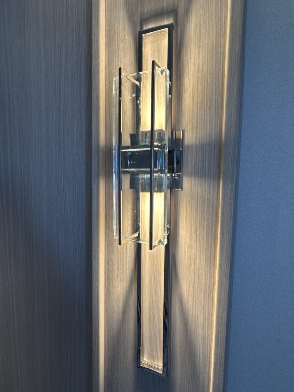 Deconstructed style of sconce in hallway with silver details and no shade