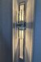 Deconstructed style of sconce in hallway with silver details and no shade