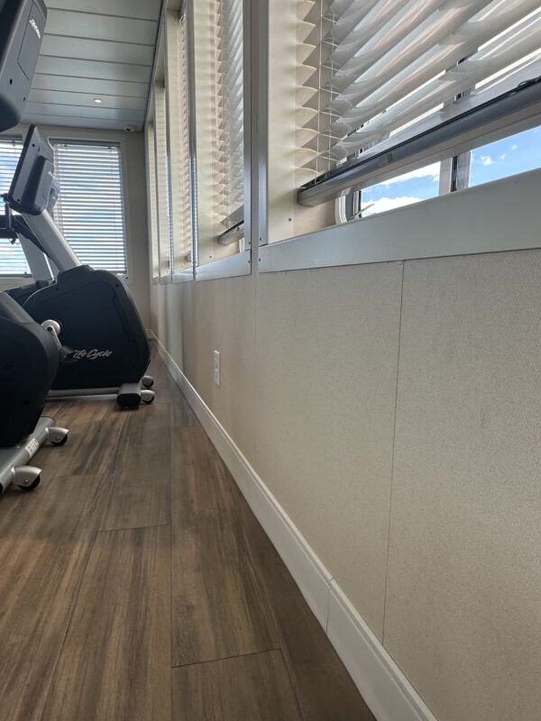 View of floorboards and venetian blinds in fitness center