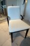 Smooth white chair with dark wood arms and legs and gold joints