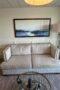 Brushed beige couch with two cushions and brass studs