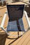 Deck chair with white arms and blue mesh seat and back.