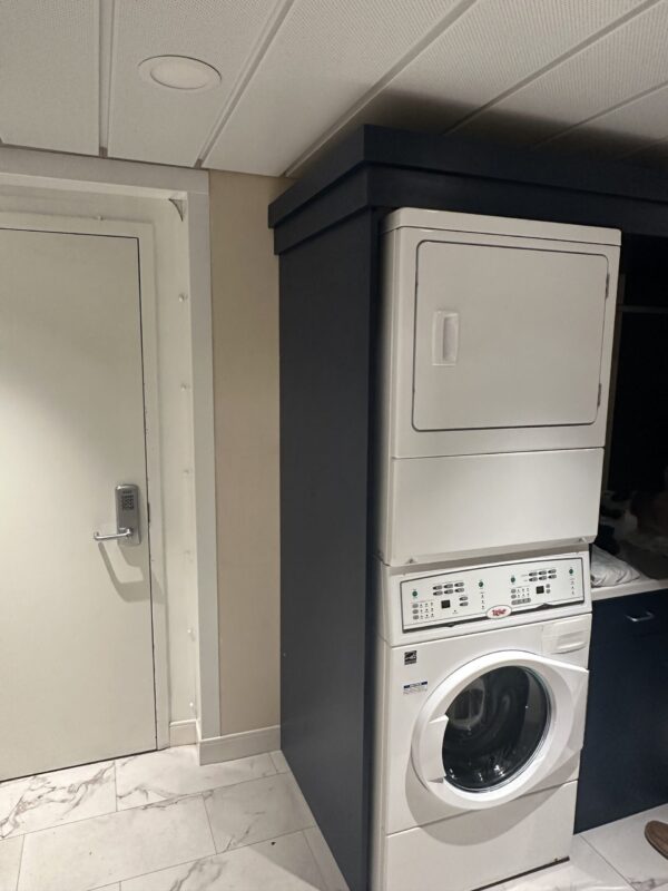 Front Load white washing machine below front load dryer