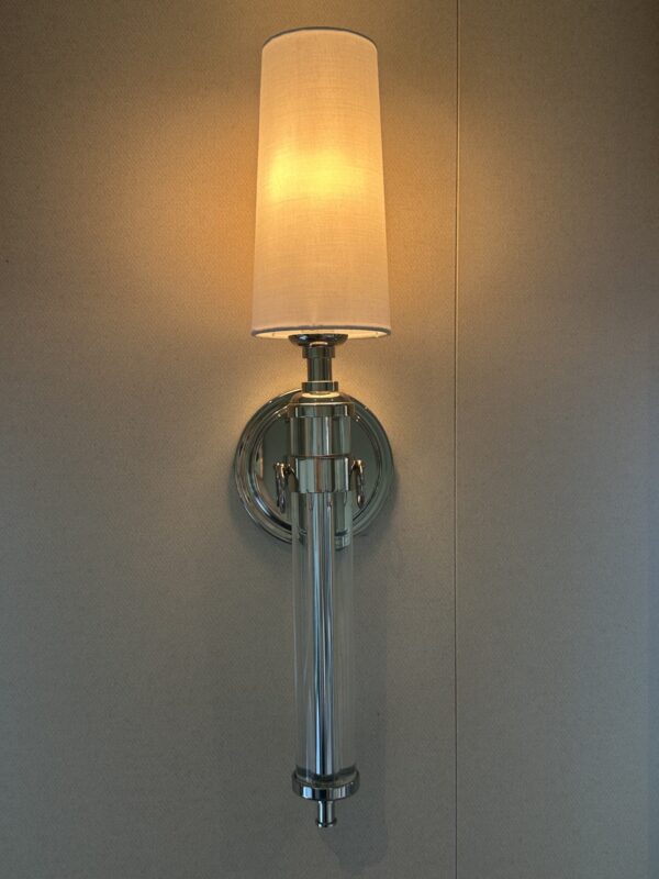 Sconce lighting with silver hardware and thin white cylinder shade