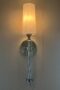 Sconce lighting with silver hardware and thin white cylinder shade