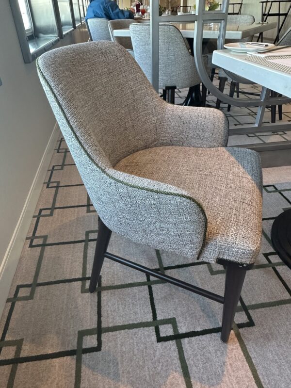 Upholstered dining chair with low arms and wooden legs